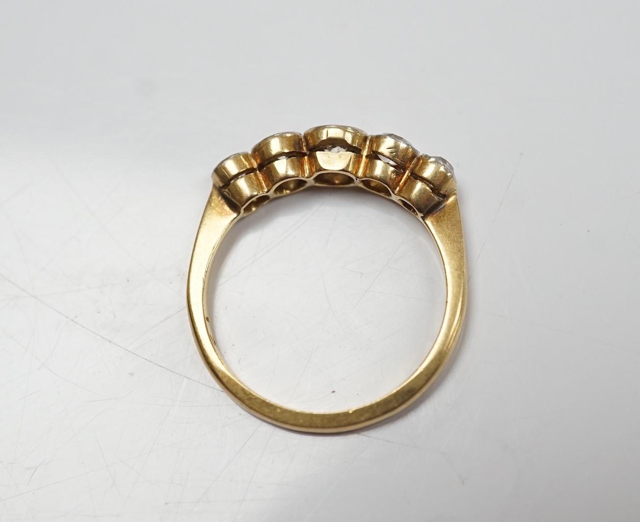 An 18ct, plat and graduated five stone collet set diamond half hoop ring, size M, gross weight 2.7 grams. Condition - poor to fair